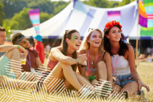 image shows girls in festival gear enjoying outdoor music event