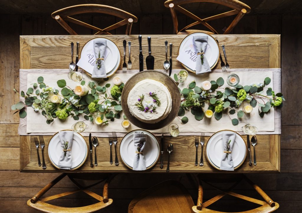 avoid five wedding disasters. Picture is of a wooden table with flowers and table sets for a rustic wedding