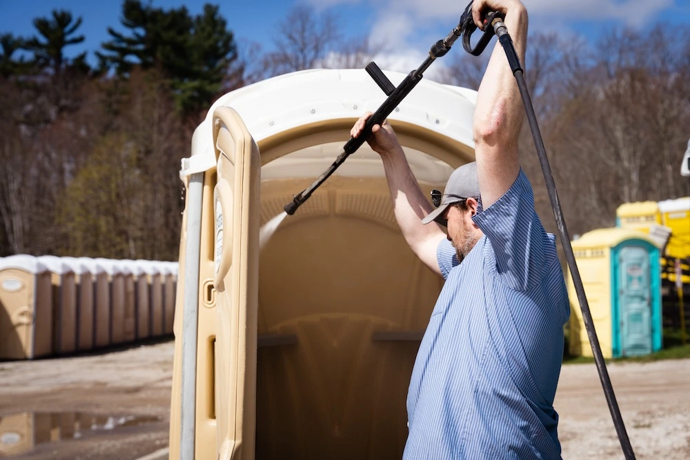 Kerkstra employee cleaning the exterior of the standard portable restroom