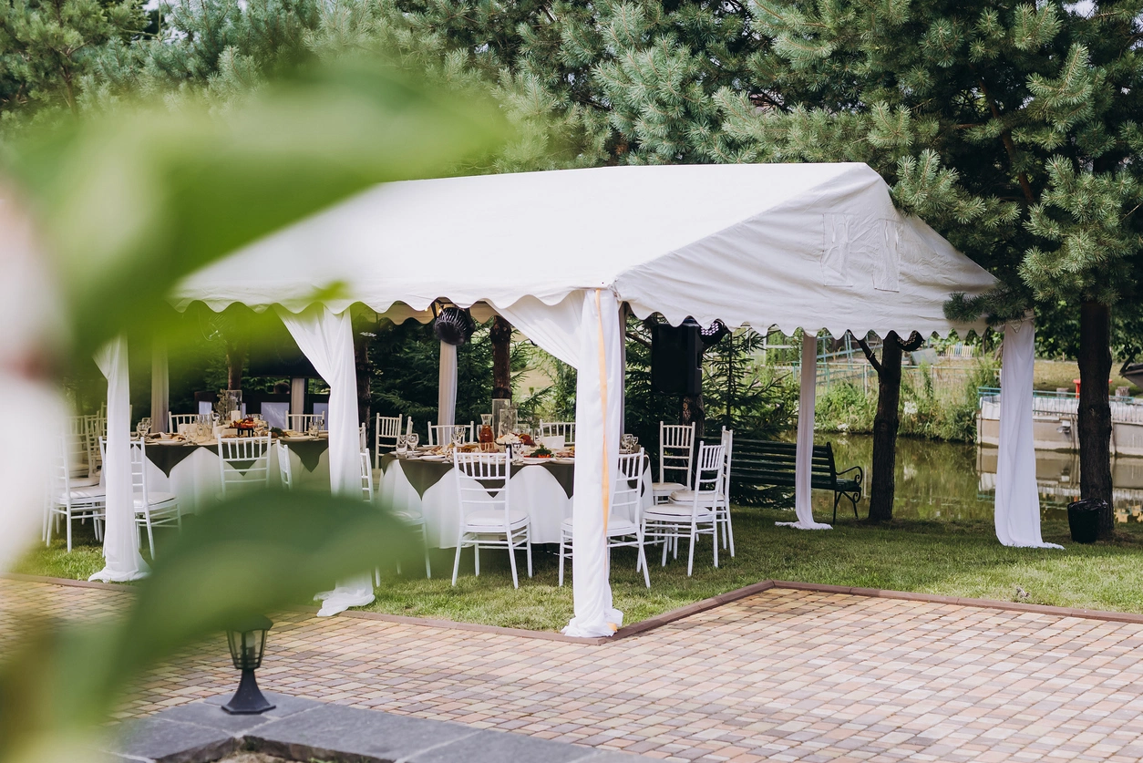 Beautiful white tent for an event surrounded by greenery